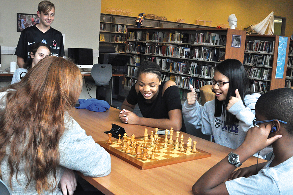 Crossroads students play chess during activity class